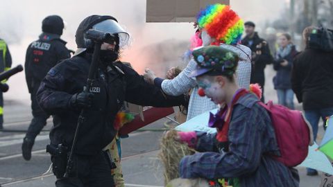 Manifestantes disfrazados de payasos se enfrentan a la polica