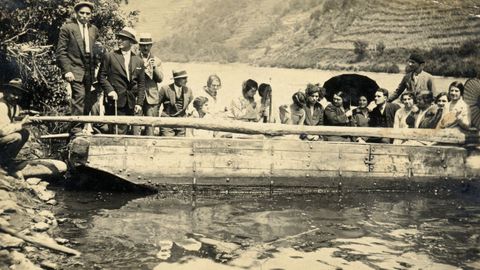 Vecinos de Sernande a bordo de una barca tradicional en una fotografía histórica