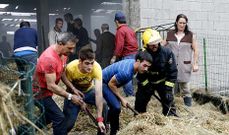 Vecinos y bomberos retiran la hierba seca almacenada en el cobertizo para extinguir el fuego que destroz� el tejado. 