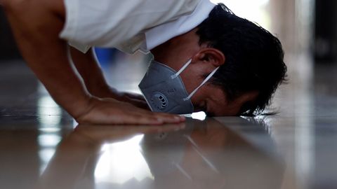 Un hombre con mascarilla ora durante el Ramadn en una mezquita de Bangkok