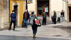 Numerosas personas esperan para acceder a un supermercado en la plaza del Font�n de Oviedo durante una nueva jornada marcada por el coronavirus.