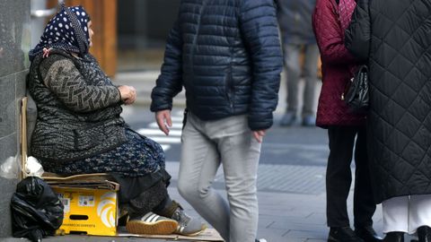 Una mujer pidiendo en la calle.