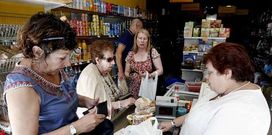 A propietaria da tenda cobrando aos clientes durante o apag�n el�ctrico, a caixa rexistradora non funcionaba.