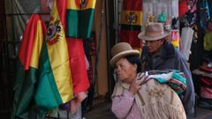 Una mujer aimara pasa frente a banderas de Bolivia en la ciudad de La Paz.