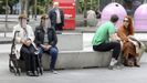 Un grupo de compostelanos descansan en un banco del centro de la ciudad