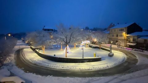 Este es el aspecto que presentaba a Cruz do Incio este lunes por la ma�ana, con las luces de Navidad de la plaza todav�a encendidas y la nieve cubri�ndola de blanco