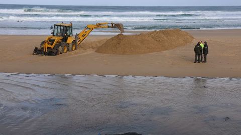 Trabajos de apertura del canal con una excavadora en la playa de Valdovio.