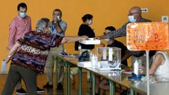 Mantener las distancias de seguridad llev� a algunos electores a hacer equilibrios, como esta votante en Burela, donde la abstenci�n super� el 48 %