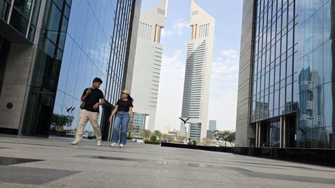 Dos j�venes caminando ayer al mediod�a entre los rascacielos de Dubai