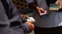 Un negociante del Gran Bazar de Teher�n cambiando riales iran�es, cuyo valor se desploma, mientras el d�lar supera los 1,8 millones en el mercado abierto