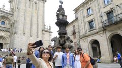 Un grupo de turistas se toma una foto ante la fuente.