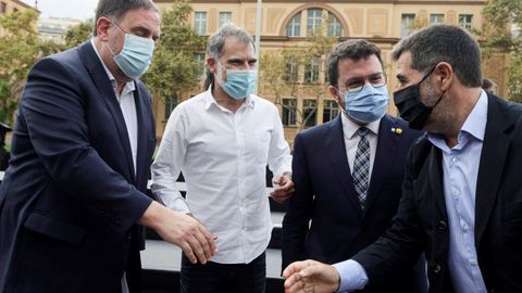 El secretario general de Junts, Jord S�nchez, saluda al presidente de ERC, Oriol Junqueras, ante el presidente de �mnium, Jordi Cuixart, y el presidente de la Generalitat, Pere Aragon�s, durante el acto de conmemoraci�n del referendo ilegal del 1-O.