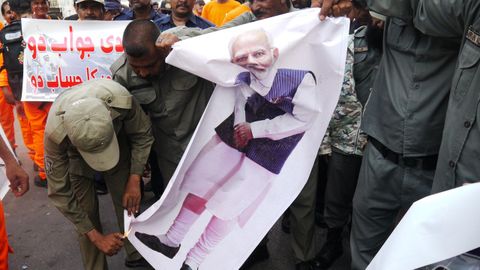 Manifestantes se disponen a quemar un retrato del primer ministro indio, Narendra Modi, durante una protesta en la ciudad pakistaní de Karachi, la más poblada del país