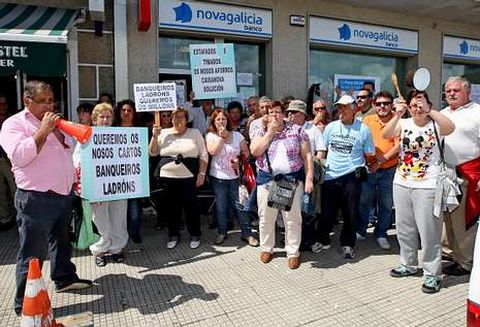 Afectados por las participaciones preferentes protestan delante de una sucursal de NCG Banco.