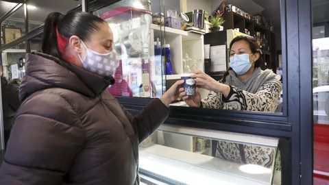 Fátima, de Dolche Café, en Bembibre (Val do Dubra), entrega un café para llevar a una clienta