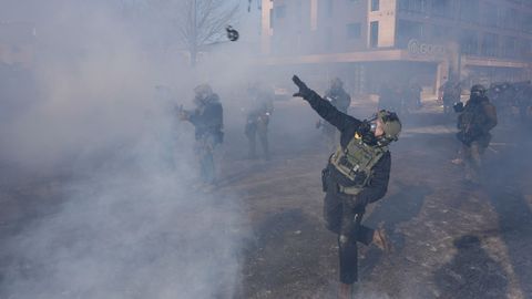 Un agente lanzando un bote de gas lacrim�geno