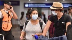 Pasajeros con mascarillas en el aeropuerto de Ezeiza, en Buenos Aires