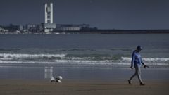 La playa de Bastiagueiro, en Oleiros, con el puerto de A Coru�a de fondo