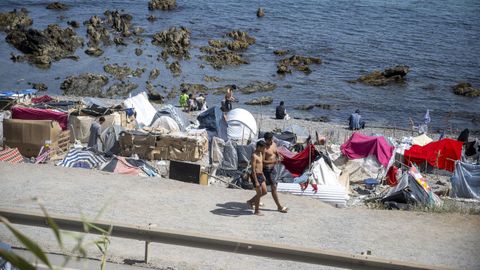 Varios migrantes acampados en la playa en Ceuta.