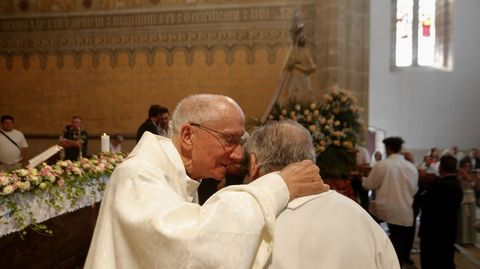 Dos de los sacerdotes que cocelebraron la misa hablan entre ellos con la imagen de la Virgen de Montserrat al fondo