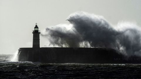 Una ola rompe sobre el faro de Newhaven, en el Reino Unido