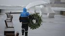 Un agente de polica lleva una corona de flores al monumento a loshroes del Orzn