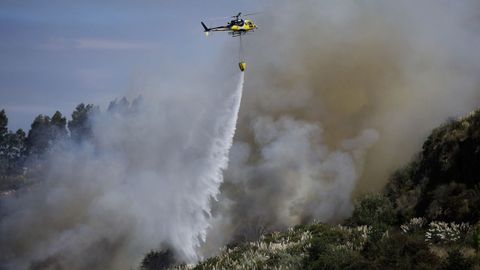 Un helic�ptero descargando agua en el incendio forestal declarado en el Concello de Culleredo. 