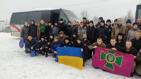 Soldados liberados de Ucrania posan con la bandera del pas y otra de las Fuerzas Armadas.