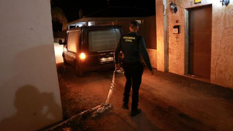 Un agente de la Guardia Civil a punto de acordonar la entrada de la casa donde se produjo el crimen, en Murcia