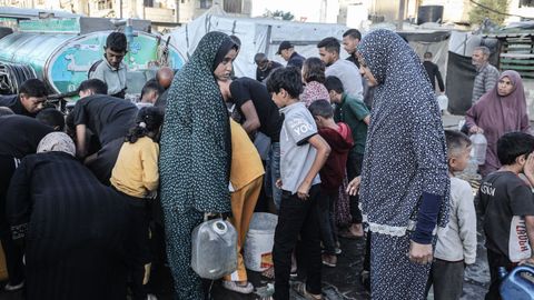 Desplazados gazates recogen agua en Al Bureij.