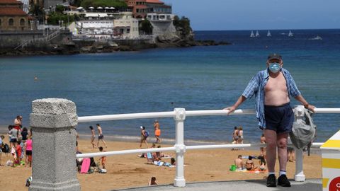Un hombre descansa frente a la playa en Gij�n