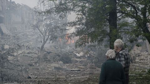 Una pareja observa los da�os causados en una escuela tras el impacto de un misil ruso, en la ciudad de Kramatorsk, en la regi�n de Donestsk