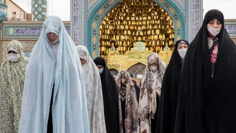 Mujeres iran�es visten tambi�n mascarillas durante los rezos ante una mezquita de Teher�n