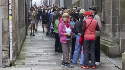 Turistas y peregrinos que esperan entrar en la catedral abarrotando una calle de Santiago
