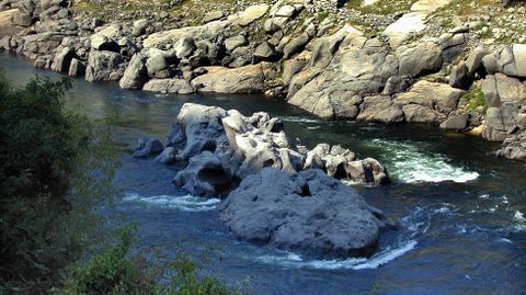 O mellor lugar para as lampreas. 200 metros augas arriba da desembocadura do río da Santa Lucía están Os Poexos, un gran penedo que parece fendido en dous. Formaban una illa no Miño na que a auga pasaba polo medio cando había chea. Era un dos mellores lugares para coller lampreas, pero un pouco perigoso. A foto está sacada no 2003, durante unha baixada de nivel que as deixou á vista