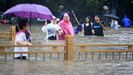 Personas caminando sobre la carretera inundada en la ciudad china de Zhengzhou