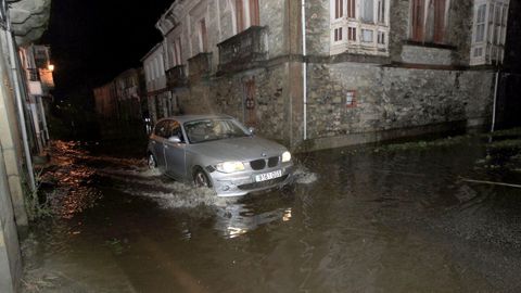 En imagen de archivo, un veh�culo intenta cruzar por la LU-161 a la altura del puente de Landrove, en Viveiro, durante un temporal que provoc� el desbordamiento del r�o Landro