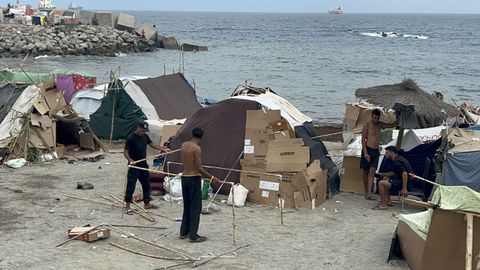 Migrantes en un nuevo asentamiento, en la playa de Ben&iacute;tez, en Ceuta.