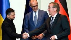 El ministro de Defensa alem�n, Boris Pistorius, estrecha la mano del presidente ucraniano, Zelensky (izquierda), junto al canciller alem�n Friedrich Merz durante la firma de un acuerdo germano-ucraniano de cooperaci�n en empresas militares