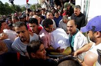 Los m�dicos cargan el cuerpo del l�der opositor asesinado mientras se forma una marcha.