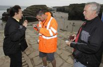 Visitantes cogiendo los pases con ayuda del personal de la Xunta que vigila e informa sobre el plan. 