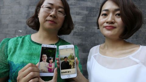 Wang Qiaoling (i) y Li Wenzu muestran las fotograf�as de sus respectivos maridos, los abogados de derechos humanos Li Heping y Wang Quangzhang, en una foto de archivo.