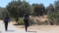 Dos guardias civiles patrullan por el lugar donde se encontraron los restos de la mujer de 70 a�os presuntamente asesinada por su hija y su yerno