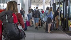 Viajeros ante el bus urbano que cubre la ruta con el aeropuerto de Lavacolla, en foto de archivo
