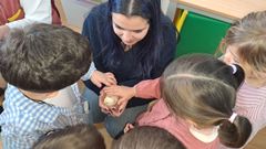 <span lang= gl >Varios escolares e unha docente cun piti�o na man</span>