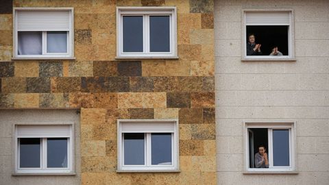 Aplausos en las ventanas de un edificio