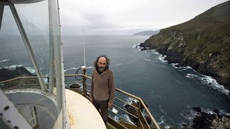 El farero, en la torre, con los acantilados al fondo, en una fotografa realizada en 2014