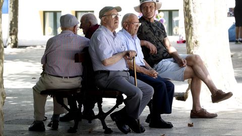 Un grupo de personas mayores sentadas en un banco.