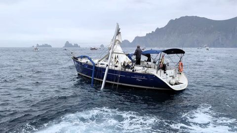El velero, con el palo roto, remolcado por la Salvamar Shaula, con Os Aguill�ns y el cabo Ortegal al fondo
