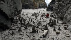 Imagen de archivo de hitos y figuras que tiempo atrs hacan los visitantes en la playa de As Catedrais